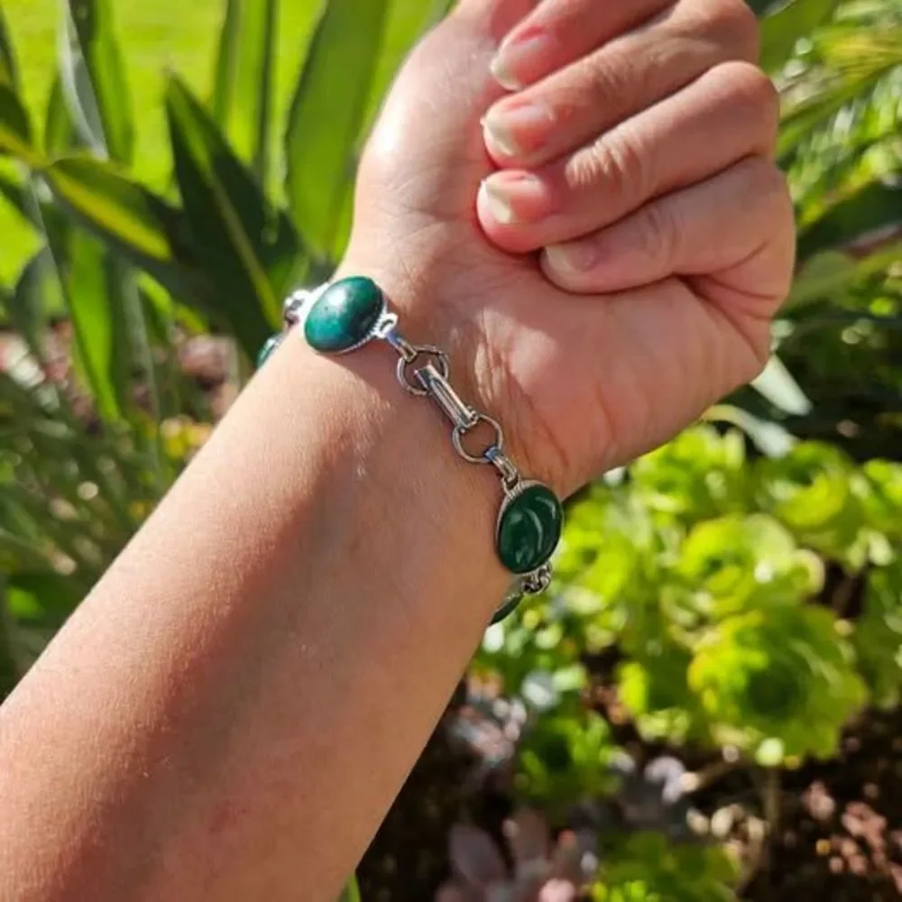 Malachite bracelet features natural green gemstones set in a silver colored link